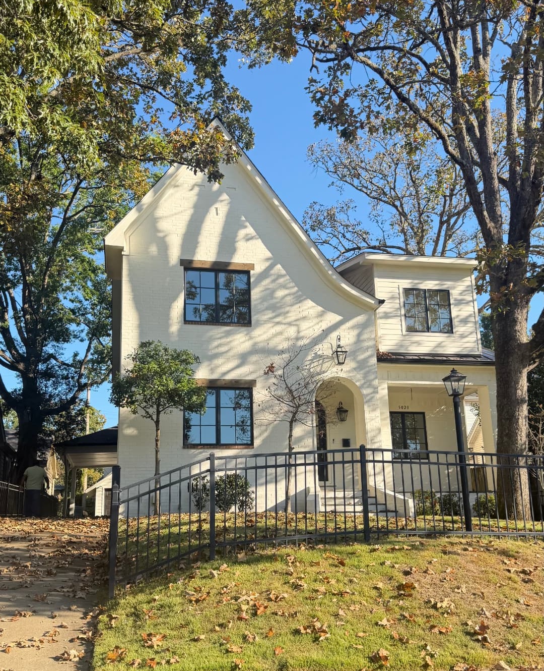 Completed light-colored house exterior with dark window trim